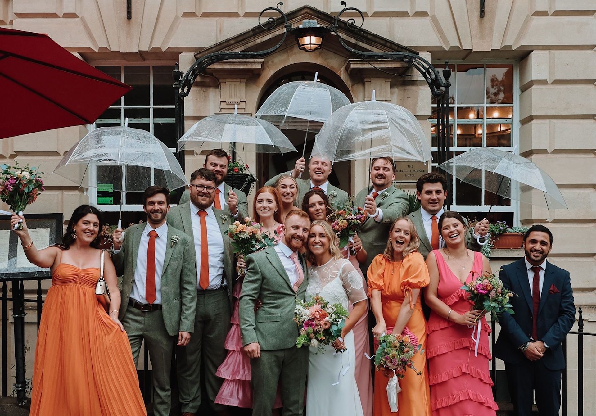 A wedding party stands outside the iconic Square Club, an iconic wedding venue in Bristol designed for couples looking for something less traditional but still elevated and unforgettable.